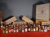 plusieurs bouteilles d'alcool posées sur une table à côté d'une caisse en bois