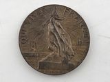 an old coin with a statue on it sitting on a white surface