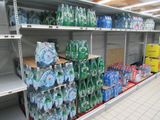 many bottles of water on the shelves in the store