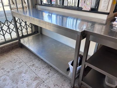 a stainless steel table with a shelf underneath it