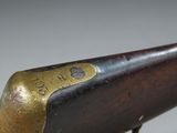 an old rifle with a brass plate on the side of it