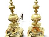 pair of antique brass candlesticks with a clock on each of them
