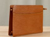 a brown leather wallet sitting on top of a wooden table