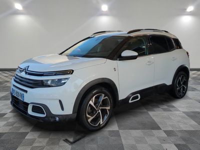 une Citroën blanche garée dans une pièce au sol en damier