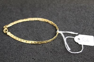 a close up of a gold bracelet with a tag on it