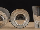 four glass vases sitting on a table next to each other