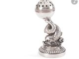 une figurine en argent surmontée d'une boule