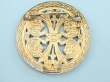 an image of a gold broochle on a blue background