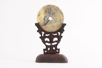 a stone object on a wooden stand on a white background