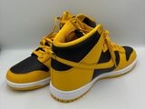 a pair of yellow and black sneakers on a white surface