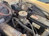 an old car engine with a rusted cover on it ' s hood