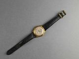 an image of a watch on a gray surface with a black strap