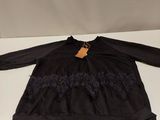 a black dress with black lace and a brown tag on it