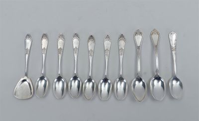 six cuillères en argent sont alignées sur une surface grise