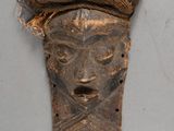 a mask on the wall with a snake on it
