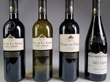quatre bouteilles de vin sont alignées sur une table
