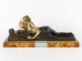 an image of a bronze statue of a woman laying on a marble base