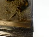 une statue en bronze représentant un cheval avec une corde sur le dos