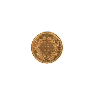 gros plan d'une pièce d'or sur une surface blanche