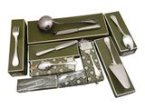 many different types of silverware in a green box
