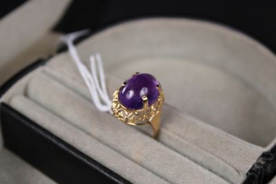 une bague sertie d'une pierre violette, dans un écrin