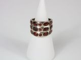 a close up of a silver ring with garnets on it