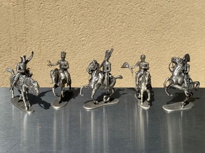 five figurines of men riding on horses on a table