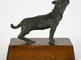 bronze statue of a dog on a wooden base on a white background
