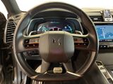 the interior of a car with a steering wheel and dashboard controls