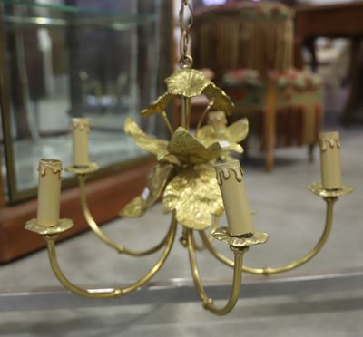 a gold chandelier with candles on it in a glass case