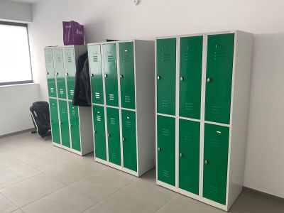 Plusieurs casiers verts sont alignés le long d'un mur dans une pièce