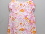 a pink and orange floral dress hanging on a hanger