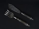 two forks and a knife on a black surface