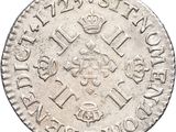 a close up of a silver coin with a crown on it