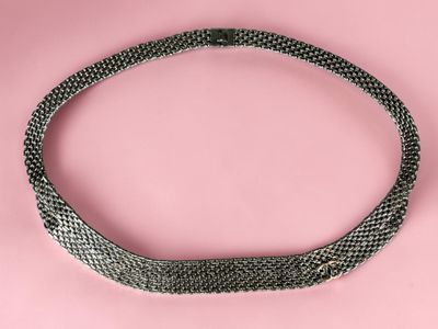 a black and white snake skin choker on a pink background