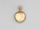 une montre de poche en or antique avec une chaîne, posée sur une surface blanche