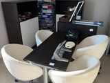 une table noire entourée de quatre chaises blanches
