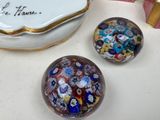 three glass marbles sitting on a table next to a box