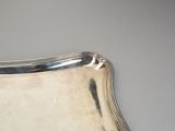 a silver plate with a curved edge on a table