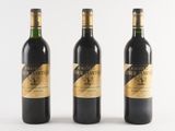 three bottles of wine are lined up on a white surface