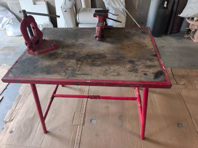 une table rouge sur laquelle sont posées deux pinces