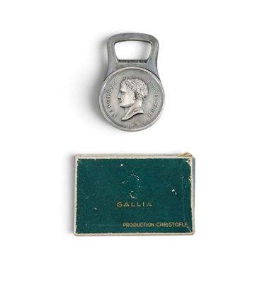 une vieille pièce de monnaie à laquelle est fixé un décapsuleur