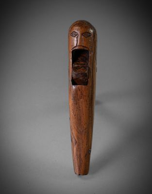 une vieille pipe en bois sur laquelle est sculpté un visage