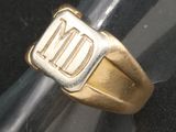 une bague en or sur laquelle sont gravées les lettres « nd »