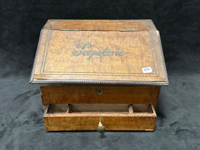 une vieille boîte en bois portant une inscription, posée sur une surface noire