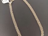 un collier composé de perles et de perles dorées sur un fond noir