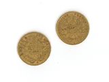 deux pièces d'or sur une surface blanche avec un fond blanc