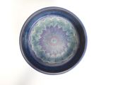 a blue and purple bowl with a flower design on it