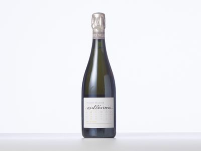 une bouteille de vin posée sur une table blanche