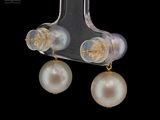 a pair of earrings with pearls hanging from them